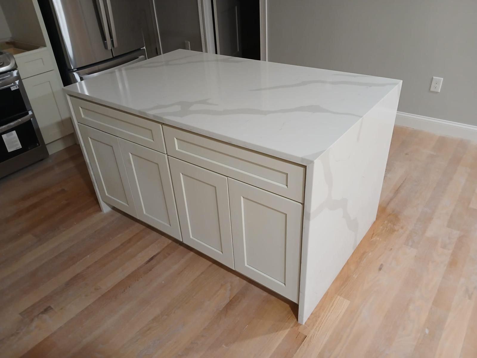 Bright kitchen with white cabinets and countertops, highlighting the craftsmanship of Marble and Granite Services